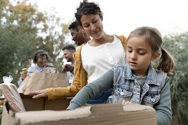 Mutter und Kind packen Pakete bei einer Spendenaktion