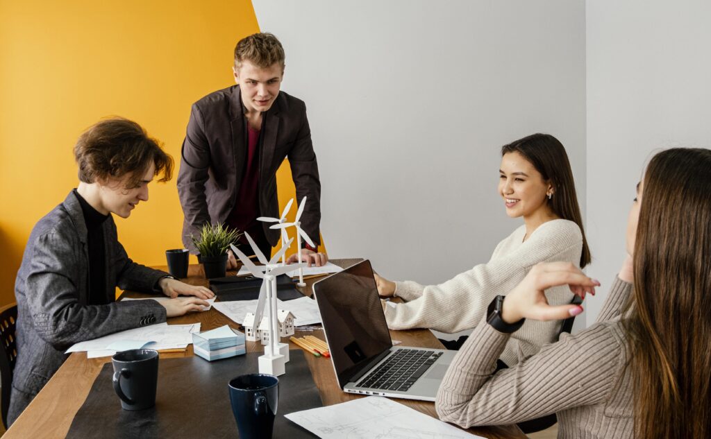Team arbeitet gemeinsam an nachhaltigem Projekt mit Windrad-Modell
