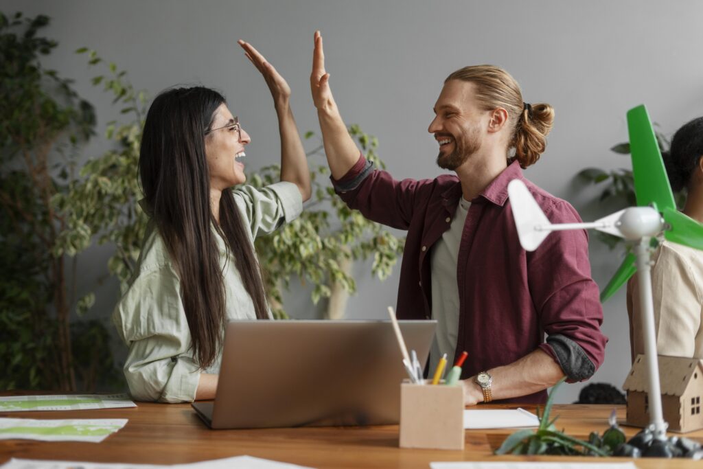Kollegen geben sich ein High-Five im nachhaltigen Büro