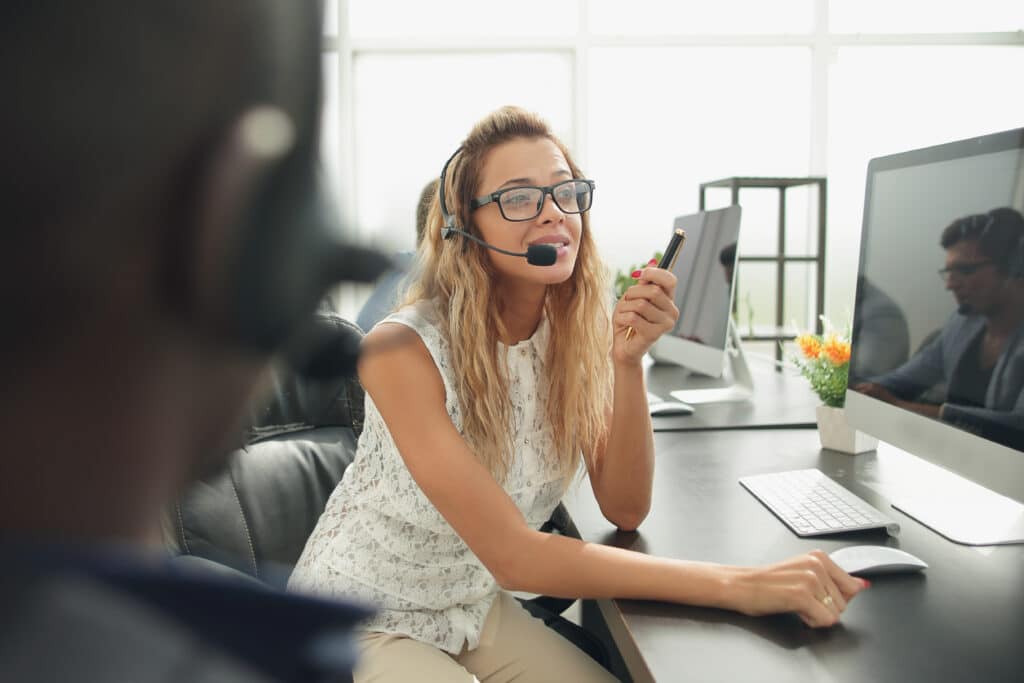 Eine Frau mit Headset arbeitet am Computer