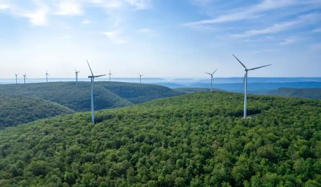 Nachhaltigkeit: Windkraftanlagen auf bewaldeten Hügeln in nachhaltiger Landschaft