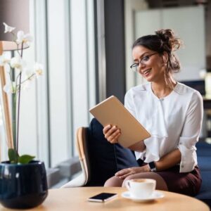 Geschäftsfrau arbeitet mit Tablet in moderner Office-Lounge